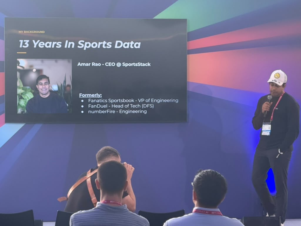 Amar beside the 13 Years in Sports Data slide